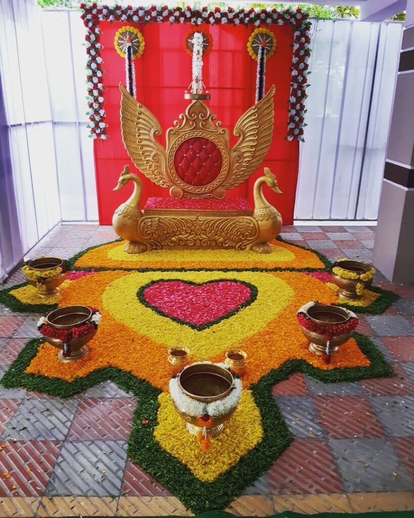Traditional ceremony setup with swan throne and petal rangoli